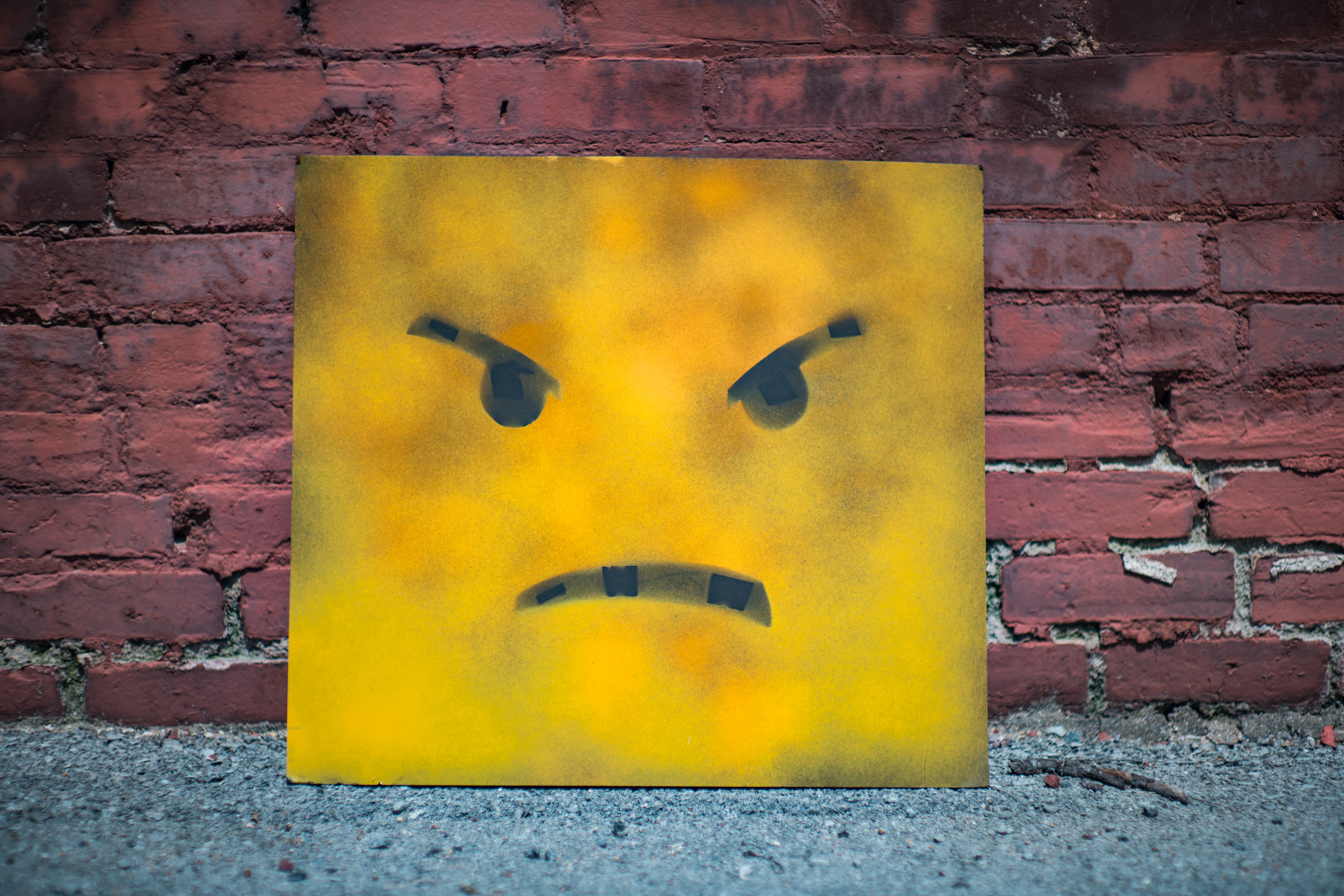 tablón amarillo con cara de enfado apoyado en la pared